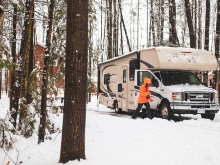 Camper brushing off their class C motorhome in the winter