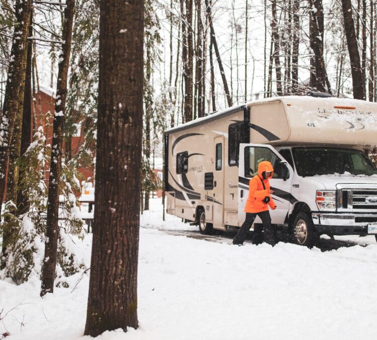 Camper brushing off their class C motorhome in the winter